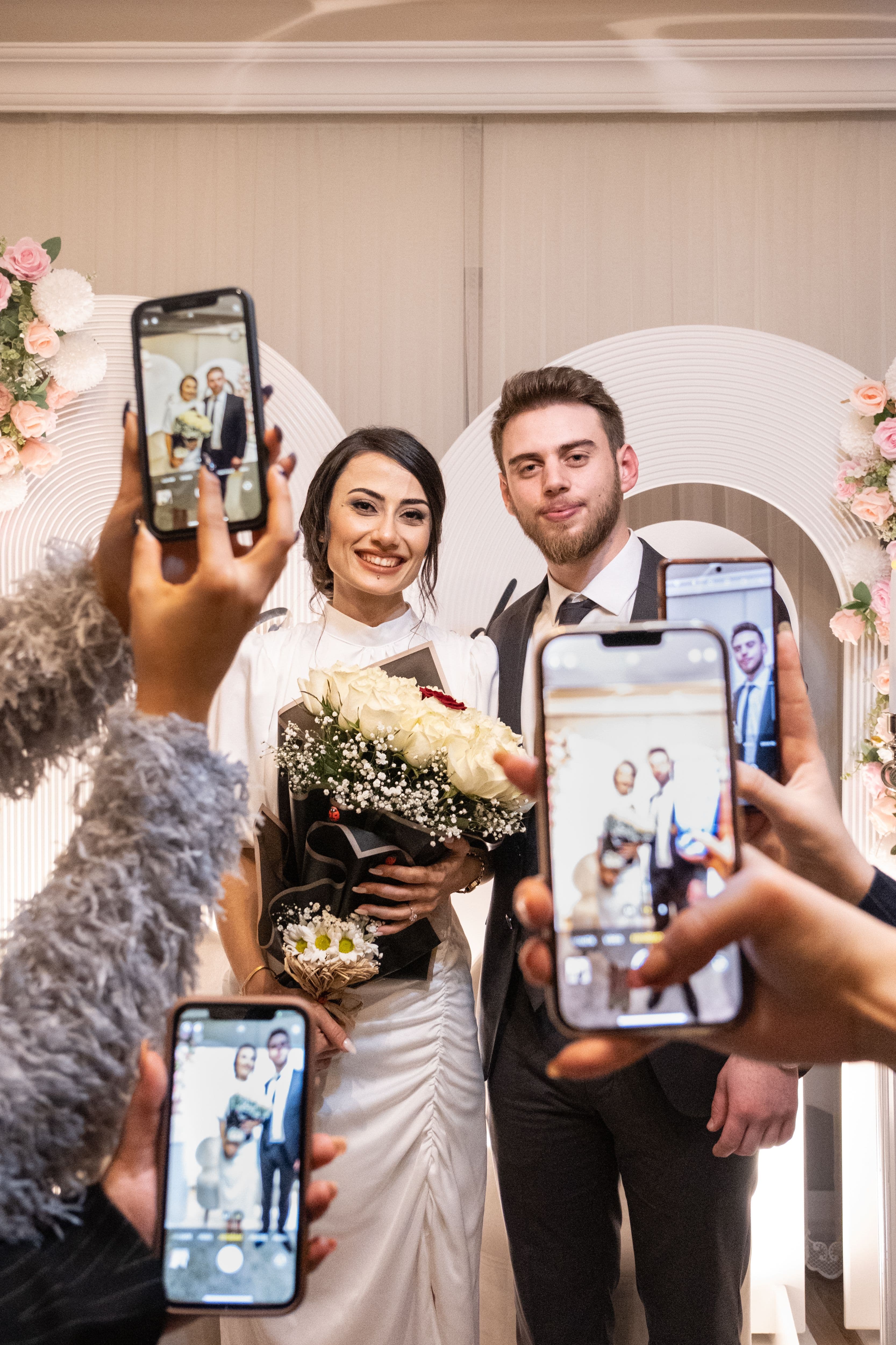 Wedding guests taking photos of the newlyweds with their phones