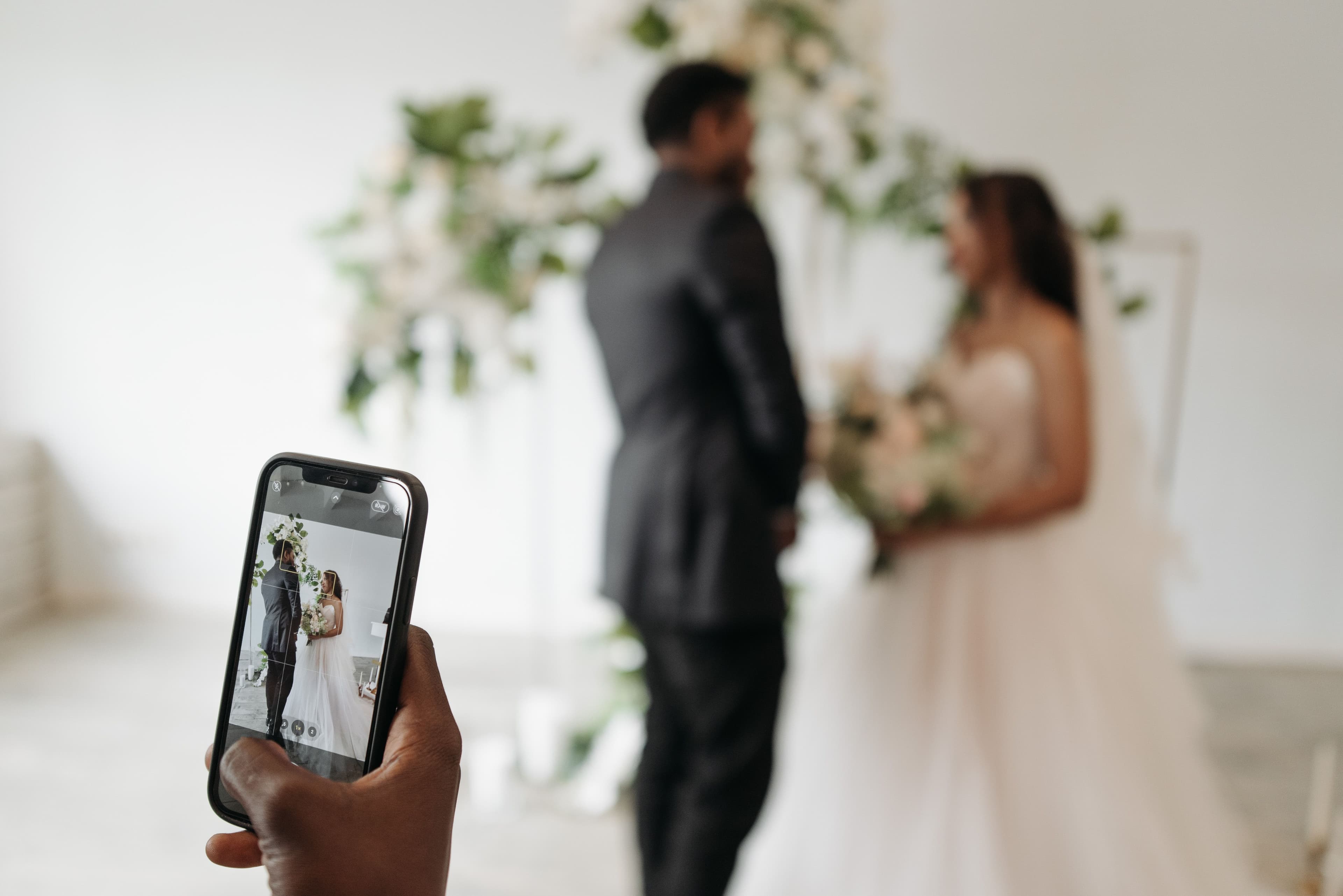 Celular fotografiando a los novios durante la ceremonia de la boda